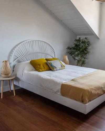 a white bed with yellow pillows in a bedroom at Casa Rural Camino Blanco in Burgos