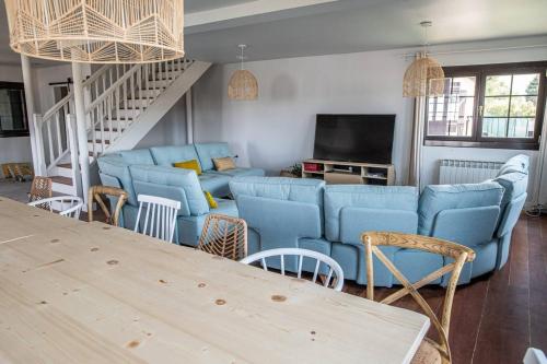 a living room with blue couches and a television at Casa Rural Camino Blanco in Burgos