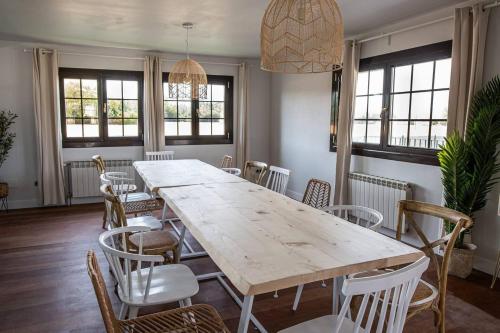 a dining room with a large wooden table and chairs at Casa Rural Camino Blanco in Burgos