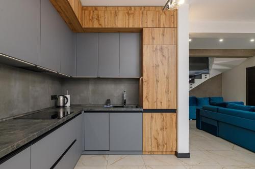 an open kitchen and living room with a blue couch at Chalet 348 in Palyanytsya