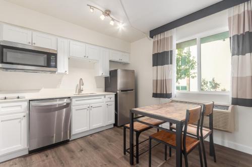 a kitchen with white cabinets and a table and chairs at Tempe Oasis in Tempe