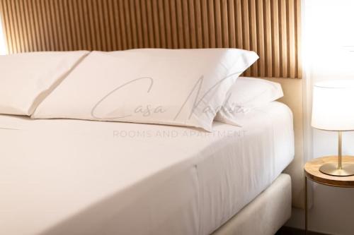 a white bed with white pillows on top of it at Nadia Apartment in Chioggia