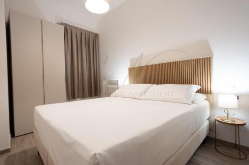 a bedroom with a large white bed with a white bedspread at Nadia Apartment in Chioggia