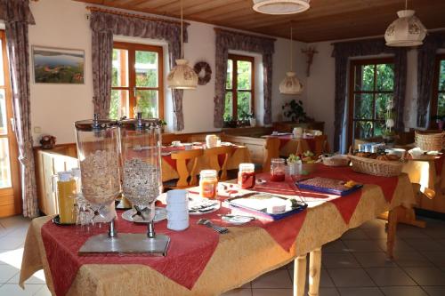 una sala da pranzo con un tavolo con una tovaglia rossa di Pension Seerose a Pleinfeld