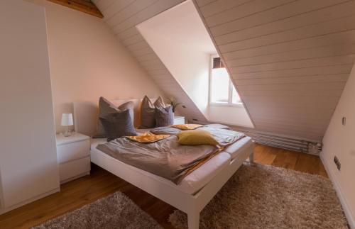 Schlafzimmer im Dachgeschoss mit einem Bett und einem Fenster in der Unterkunft Altstadthaus "Schlägertwiete Nr.3" in Lüneburg