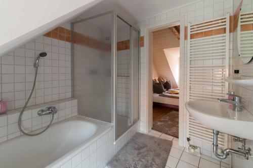 een badkamer met een douche, een bad en een wastafel bij Altstadthaus "Schlägertwiete Nr.3" in Lüneburg