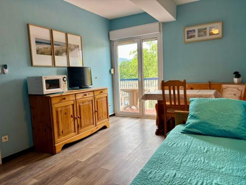 - une chambre avec un lit et une télévision sur une armoire en bois dans l'établissement Belle Appartement T2 Plage Centrale Argeles sur mer, à Argelès-sur-Mer