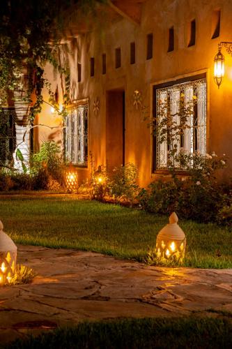 a house with lights in the yard at night at Villa Sidi Oasis in Marrakech