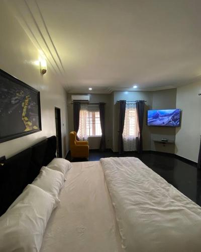 Mamaにあるjazmine suitesの薄型テレビ付きの客室の大型ベッド1台分です。