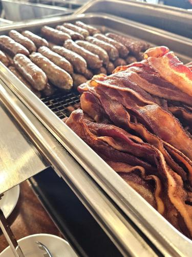 a tray of bacon and sausages on a grill at Linekin Bay Resort in Boothbay Harbor