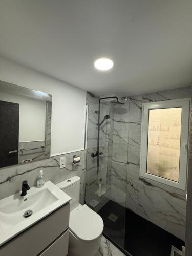 a bathroom with a toilet and a sink and a shower at Boomerang in Benidorm