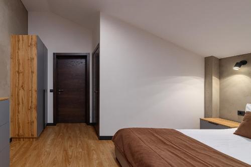 a bedroom with a bed and a wooden door at Chalet 348 in Palyanytsya