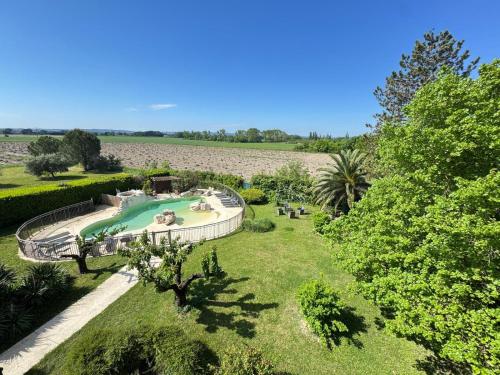 une vue aérienne d'une piscine dans un jardin dans l'établissement La Bastide des Princes - Aile gauche, à Caderousse