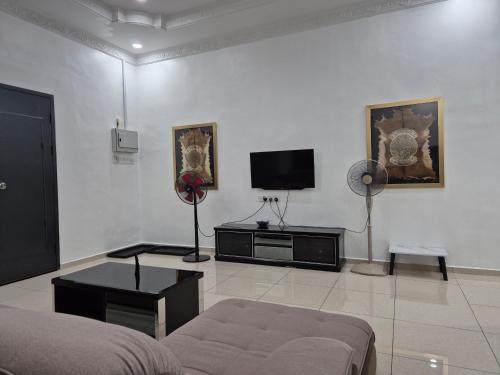 a living room with a couch and a flat screen tv at Quantum MiCasa in Muar