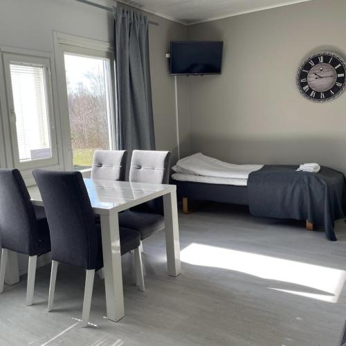 a room with a table and chairs and a bed at Hotelli Kontio in Kontiolahti