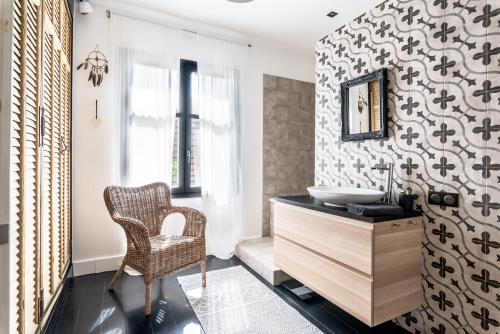 La salle de bains est pourvue d'un lavabo et d'une chaise. dans l'établissement S1 Villa Fleur de Cacao, à Opio