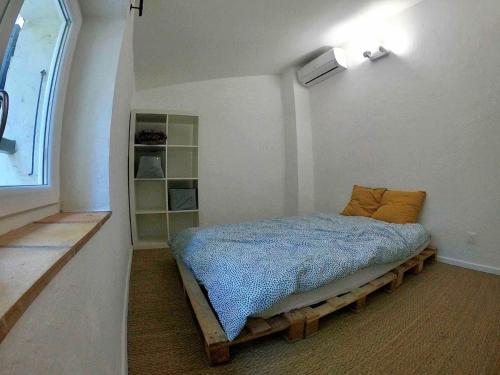 une chambre avec un lit dans le coin d'une pièce dans l'établissement Maison de hameau au coeur de la campagne Grimaudoise, à Grimaud