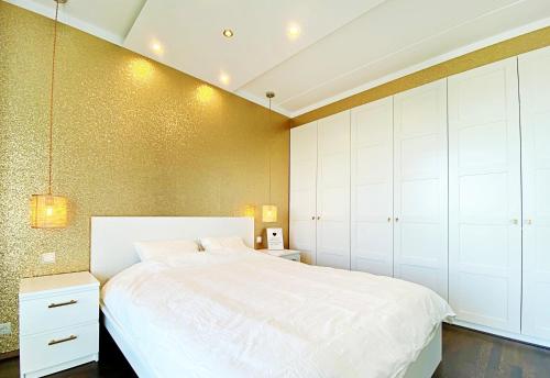 a bedroom with a white bed and white cabinets at Papiniidu Apartments in Pärnu
