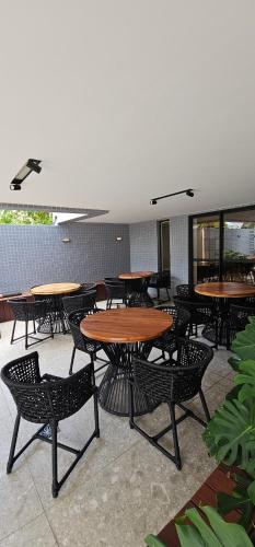 a group of tables and chairs in a restaurant at Lindo Flat no Jardim Oceania - Get One in João Pessoa