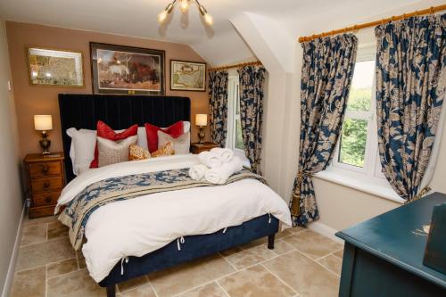 ein Schlafzimmer mit großem Bett und Fenster in der Unterkunft Thatchers Cottage - Rudge Farm Cottages in Bridport