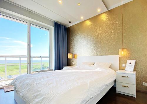 a bedroom with a large bed and a large window at Papiniidu Apartments in Pärnu