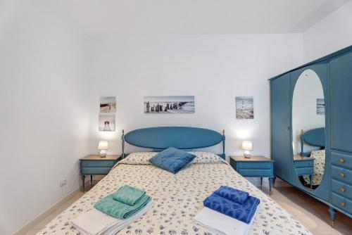 a bedroom with a bed with blue furniture and mirrors at Casa Lago Leo in Omegna