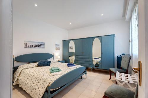 a bedroom with a blue bed and a chair at Casa Lago Leo in Omegna
