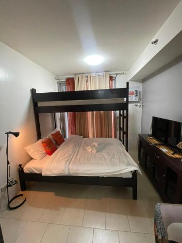 a bedroom with a large bed and a television at Makati City Antel Spa Residences 1615 in Manila
