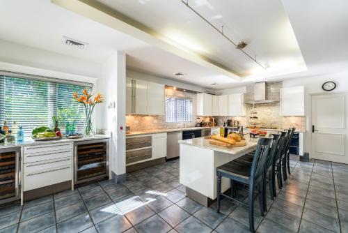 a kitchen with white cabinets and a table with chairs at Pease Bay House in Breakers