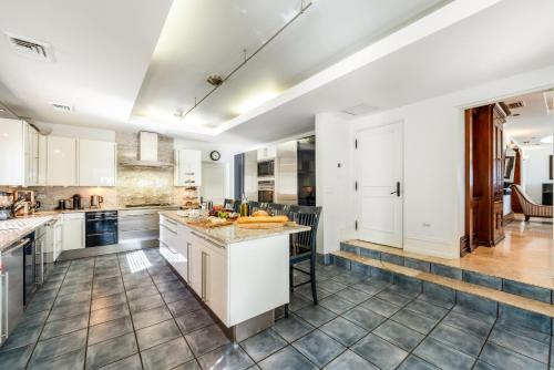 a kitchen with white cabinets and a large island at Pease Bay House in Breakers
