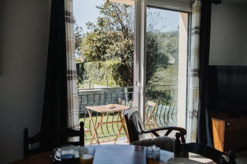 une pièce avec une grande fenêtre avec une table et des chaises dans l'établissement La Delphinière : Bord de Mer, Equipements de qualité, à Urville-Nacqueville