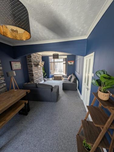 a living room with blue walls at Beautiful 2 Bedroom House Up to 4 people Hull Siemens Holderness road in Hull