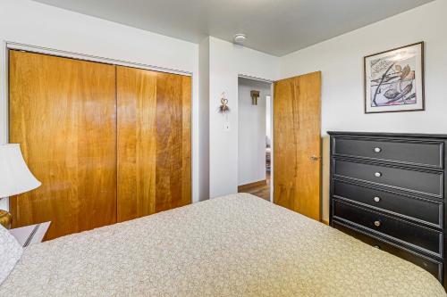 a bedroom with a bed and a wooden cabinet at Walk to Flathead Lake Airy Home with Mtn Views! in Polson