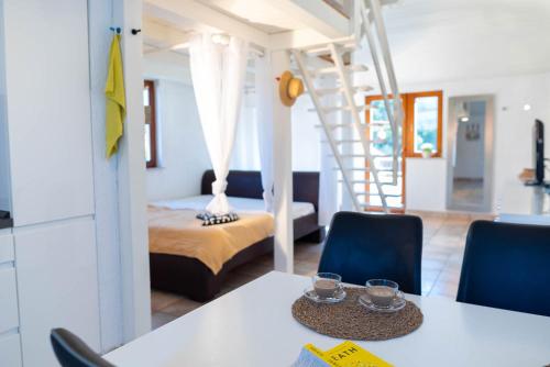 une chambre avec un lit et une table avec des chaises dans l'établissement Quirky Penthouse Apartment, à Vrboska