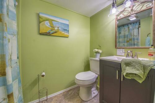 a green bathroom with a toilet and a sink at Stroll Into Town Cozy Apartment in Kilmarnock in Kilmarnock