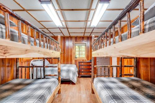 two bunk beds in a room with wooden walls at 2 Mi to GSMNP Peaceful and Scenic Cabin with Deck in Sevierville