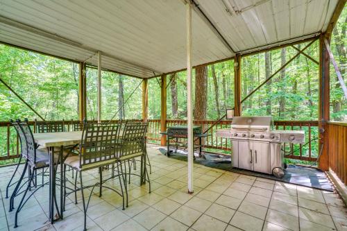 a screened in porch with a stove and a table and chairs at 2 Mi to GSMNP Peaceful and Scenic Cabin with Deck in Sevierville