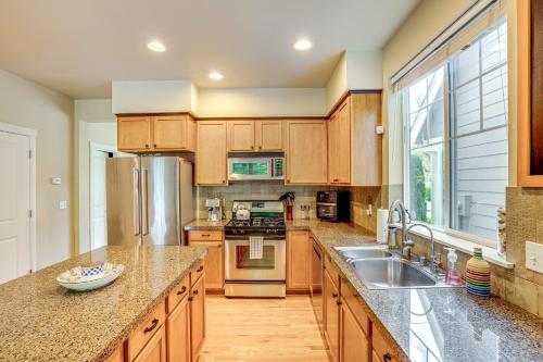 a kitchen with wooden cabinets and stainless steel appliances at 3 Mi to Dtwn Bothell Quaint Family Home with Patio in Bothell