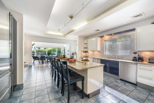 a kitchen with a large island with black chairs at Pease Bay House in Breakers