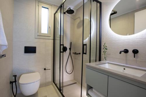 a bathroom with a shower and a toilet and a sink at Emilia Villas in Agios Nikitas