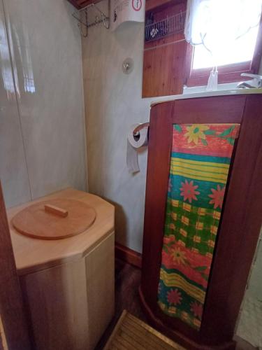une petite salle de bain avec des toilettes en bois et un lavabo dans l'établissement Roulotte Mon rêve en Normandie, à Le Mesnil-Garnier