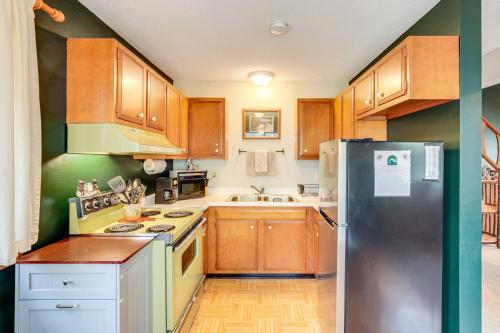 a kitchen with wooden cabinets and a refrigerator at Boat, Paddle, UTV and More Getaway in Saint Germain in Saint Germain