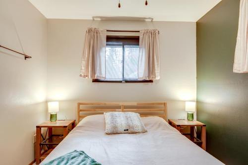 a bedroom with a bed and a window with two lamps at Boat, Paddle, UTV and More Getaway in Saint Germain in Saint Germain