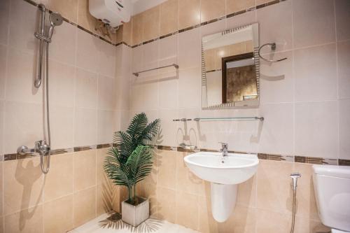 a bathroom with a sink and a plant in it at Mustang 11-11 Boutique Hotel Self Check In in Ho Chi Minh City