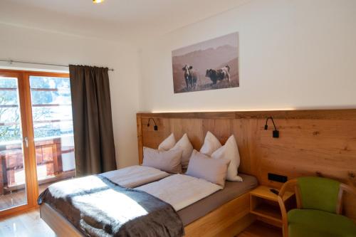 a bedroom with a bed and a chair and a window at Brandstatthof Leogang in Leogang
