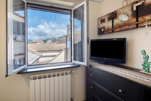 a living room with a large window and a flat screen tv at Romantica e Accogliente Mansardina in Savona