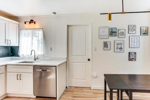 a kitchen with white cabinets and a sink and a table at 3 Mi to Emerald Downs Pet-Friendly Home in Auburn