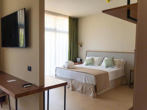 a hotel room with a bed and a television at ananea Tropea Yachting Resort in Tropea