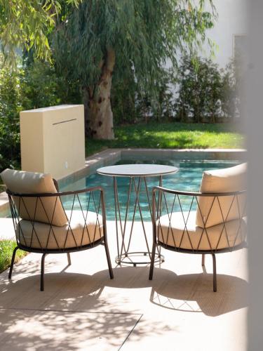 two chairs and a table in front of a pool at ananea Tropea Yachting Resort in Tropea