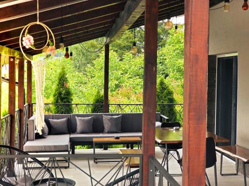 a patio with a couch and a table on a balcony at Fruška Kuća in Vrdnik